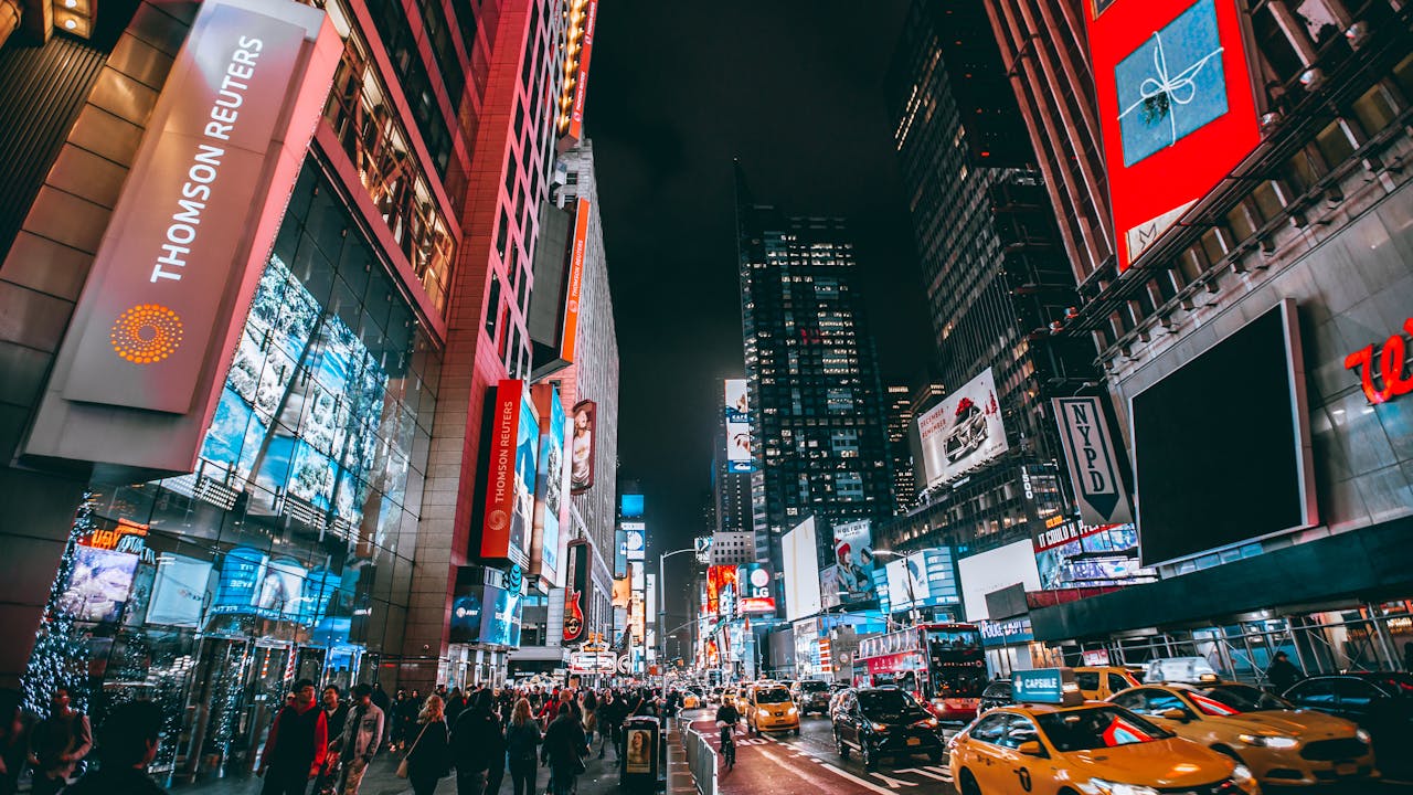 our-story Bustling evening scene in New York City's iconic Times Square, showcasing bright lights and lively atmosphere.